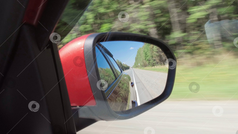 Скачать Вождение автомобиля по шоссе в солнечный день с видом из бокового зеркала. фотосток Ozero