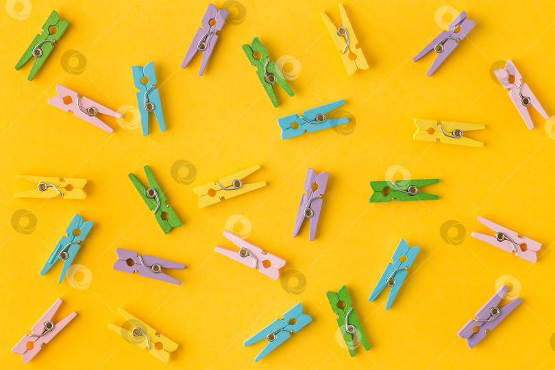 Скачать Маленькие разноцветные прищепки для одежды на желтом фоне фотосток Ozero