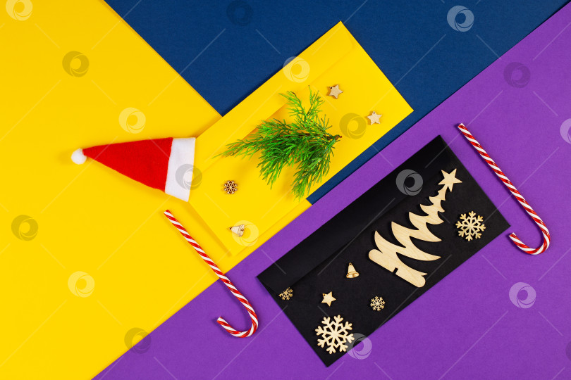 Скачать Геометрический рождественский фон на модной цветной бумаге со шляпой Санта-Клауса. фотосток Ozero