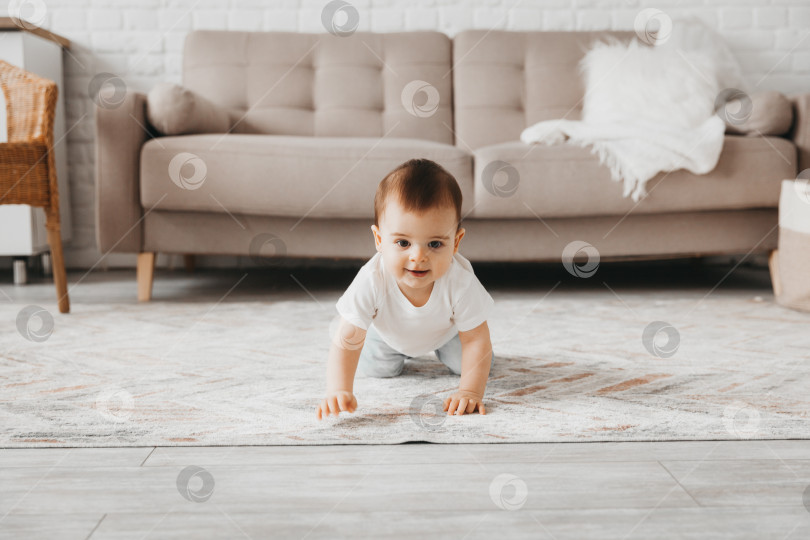 Скачать малыш в возрасте 9 месяцев учится ползать дома. ребенок ползает по полу фотосток Ozero