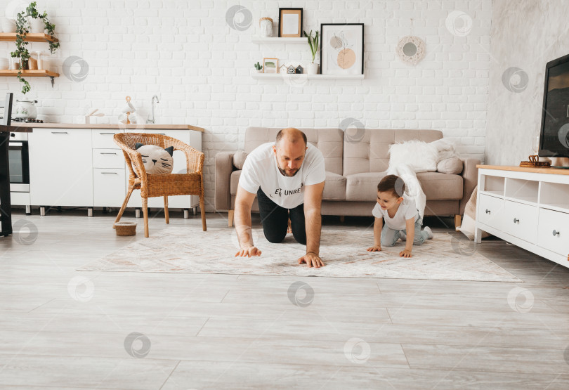 Скачать Счастливый отец играет в догонялки с детьми на полу. отец с детьми ползают по полу фотосток Ozero