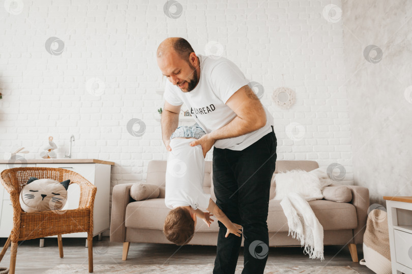Скачать Отец и сын улыбаются, проводя время вместе. отец и сын играют дома фотосток Ozero