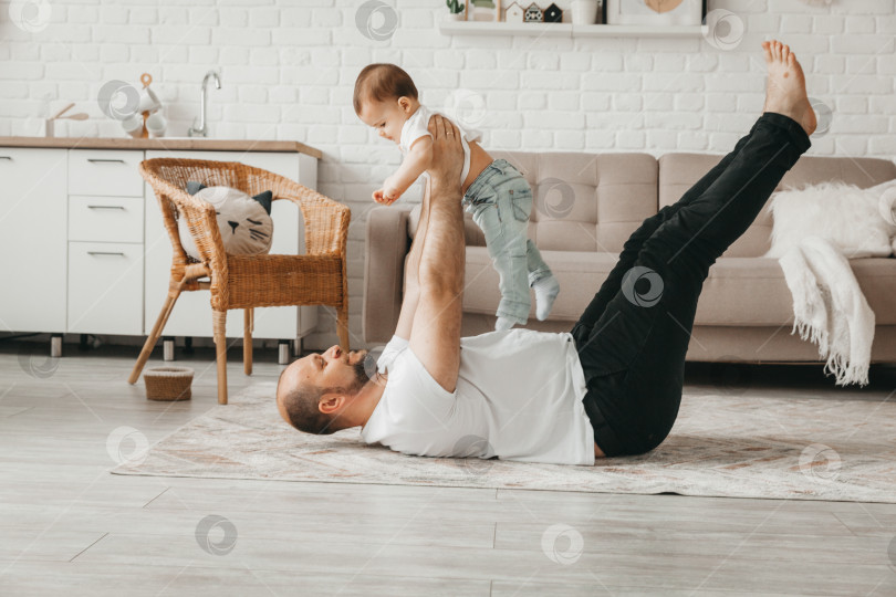 Скачать Отец и сын улыбаются, проводя время вместе. отец и сын играют дома фотосток Ozero
