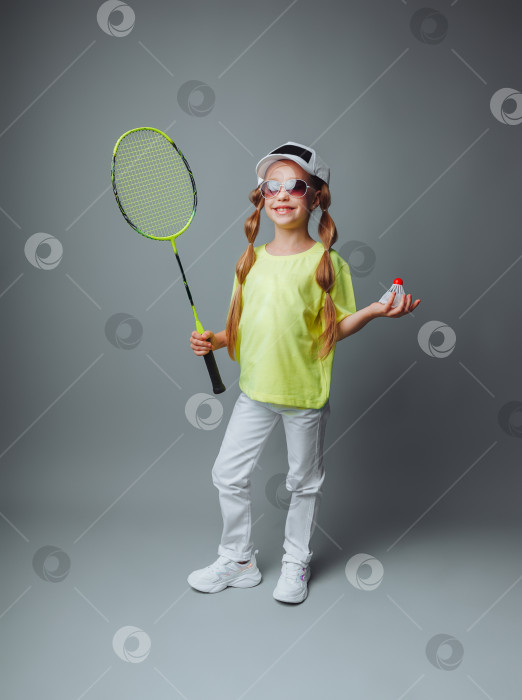 Скачать маленькая девочка держит ракетку на сером фоне. маленький игрок в теннис. Маленький ребенок играет в теннис. детский спорт. фотосток Ozero