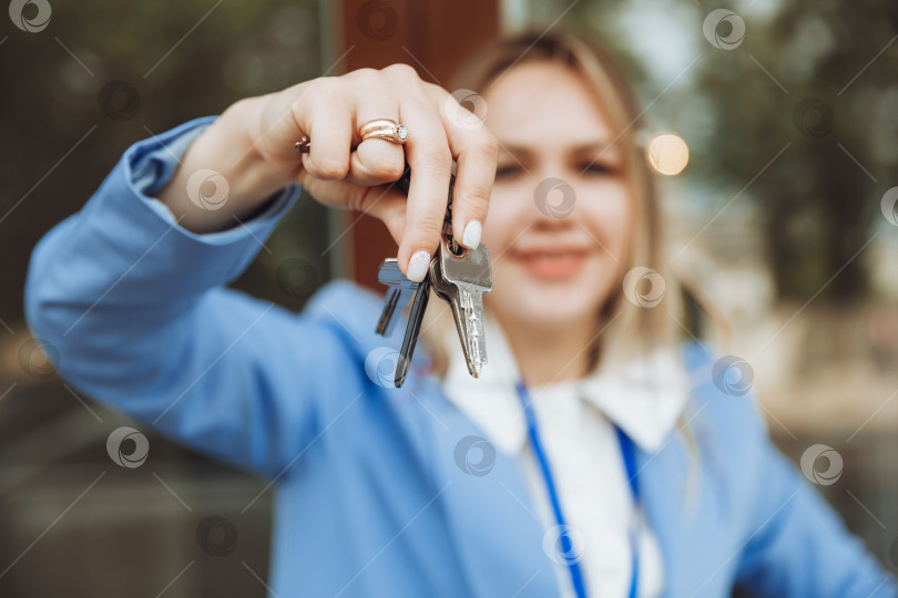 Скачать женщина-риэлтор держит ключ от квартиры в новом доме, владелица недвижимости, совершает продажу, покупает концепцию сделки с недвижимостью, крупный план фотосток Ozero