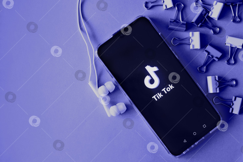 Скачать Тверь, Россия - 9 апреля 2020 года, логотип tik tok на экране смартфона с наушниками. Значок "Тик-ток". логотип текущего приложения. Социальная сеть Tiktok. Демонстрация цветов 2022 года - Очень пери фотосток Ozero