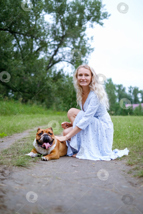 Скачать молодая женщина играет с английским бульдогом в парке фотосток Ozero