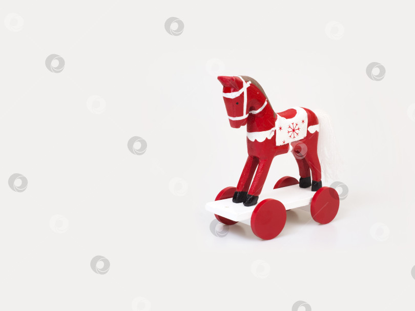 Скачать Красная лошадка на колесах (елочная игрушка), выделенная на белом фоне фотосток Ozero