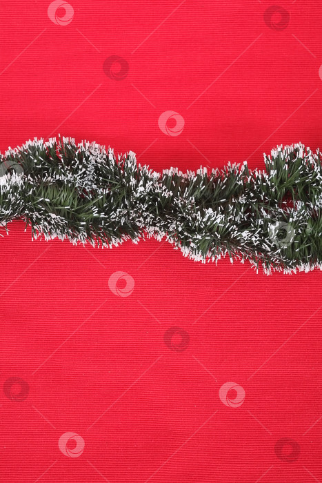 Скачать Шаблон для новогоднего поздравления: зеленая рождественская гирлянда на красном фоне фотосток Ozero