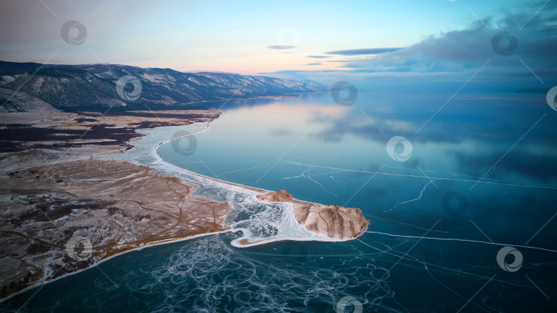 Скачать Замерзшее озеро Байкал с воздуха. Прозрачный лед, в котором отражаются облака. Зимнее путешествие. фотосток Ozero