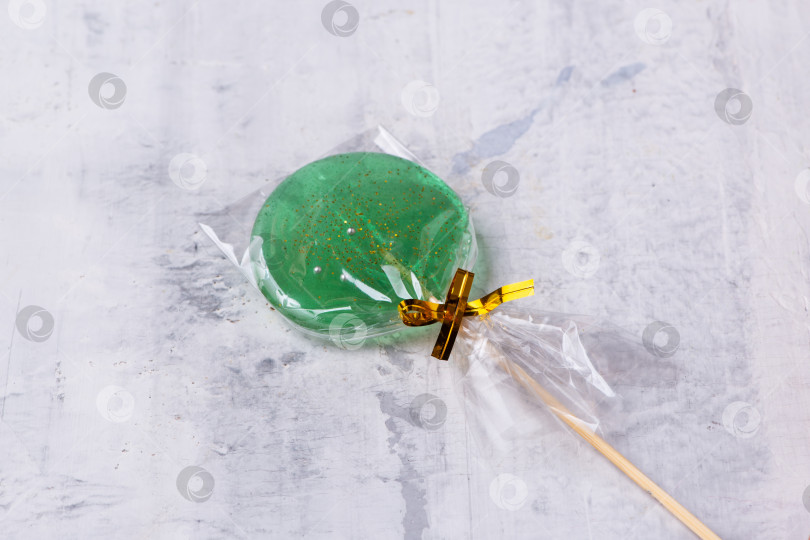 Скачать Зеленый леденец на палочке на текстурированном фоне фотосток Ozero