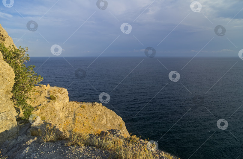 Скачать Крутой морской берег, освещенный низким вечерним солнцем. фотосток Ozero