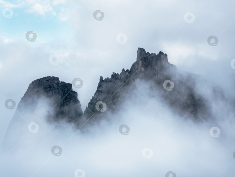 Скачать Вершины гор в белых облаках. Край отвесной скалы - это ба фотосток Ozero