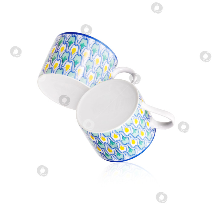 Скачать Две чайные чашки со средиземноморским орнаментом, выделенные на белом фоне. Элемент дизайна с контуром отсечения фотосток Ozero