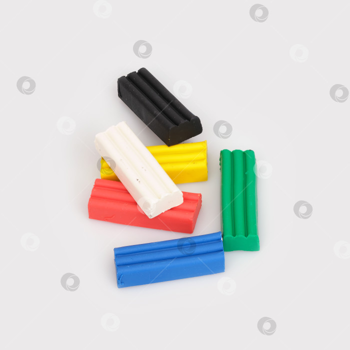 Скачать Стопка кусочков разноцветного пластилина, выделенных на белом фоне фотосток Ozero