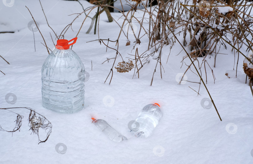 Скачать Бутылки с питьевой водой на снегу. рекламный плакат фотосток Ozero