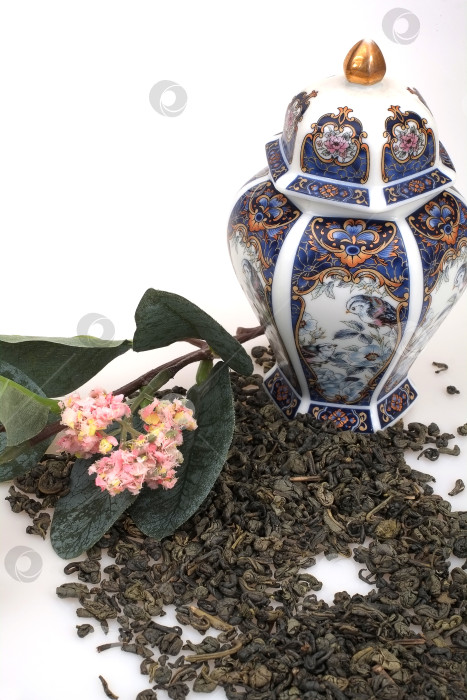 Скачать Пролитый чай, фарфоровый японский сосуд и цветущая ветка, выделенные на белом фоне фотосток Ozero