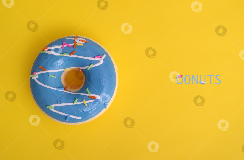 Скачать Пончик с голубой глазурью, выделенный на желтом фоне фотосток Ozero