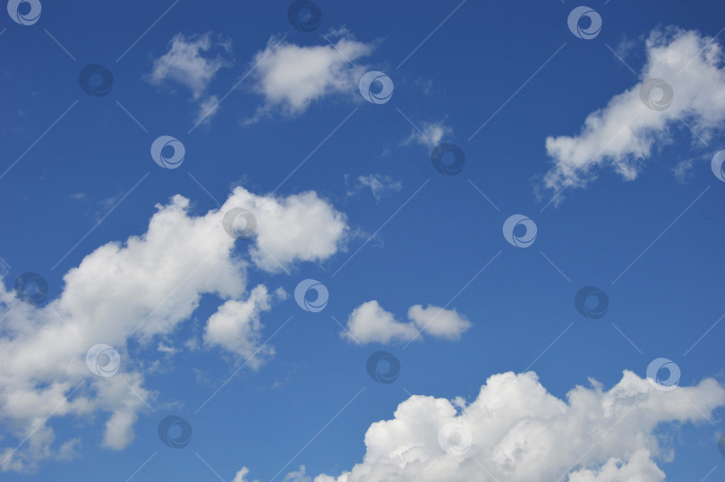 Скачать Белые объемные облака на фоне яркого ясного голубого неба в ясный день. фотосток Ozero
