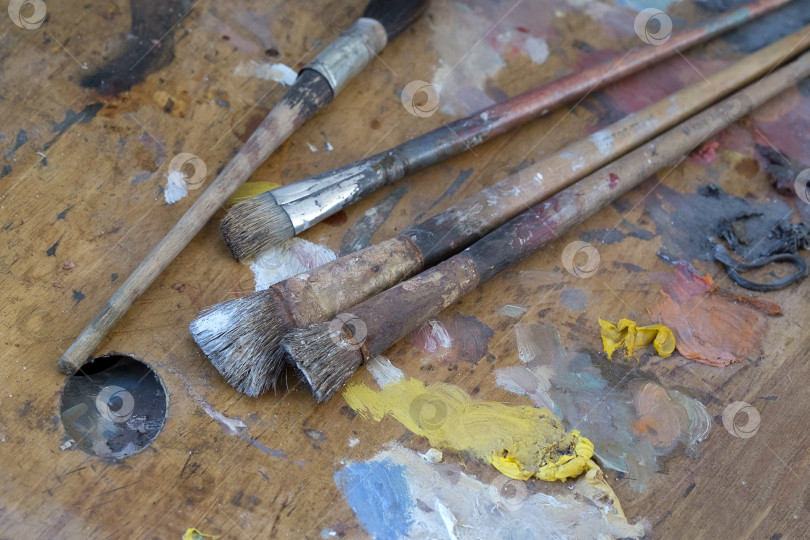 Скачать Старые кисти и краски на грязной палитре в мастерской художника фотосток Ozero