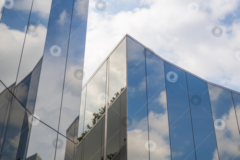 Скачать Отражение облаков и голубого неба на фасаде современного здания фотосток Ozero