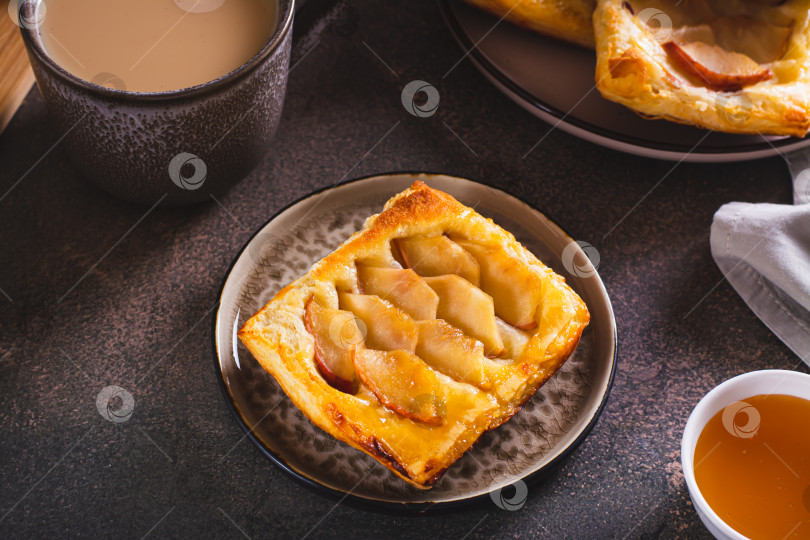 Скачать Маленький перевернутый пирог из слоеного теста с яблоком на тарелке фотосток Ozero