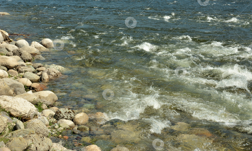 Скачать Скалистый берег небольшой бурной реки в потоке воды на поверхности в ясный летний день. фотосток Ozero