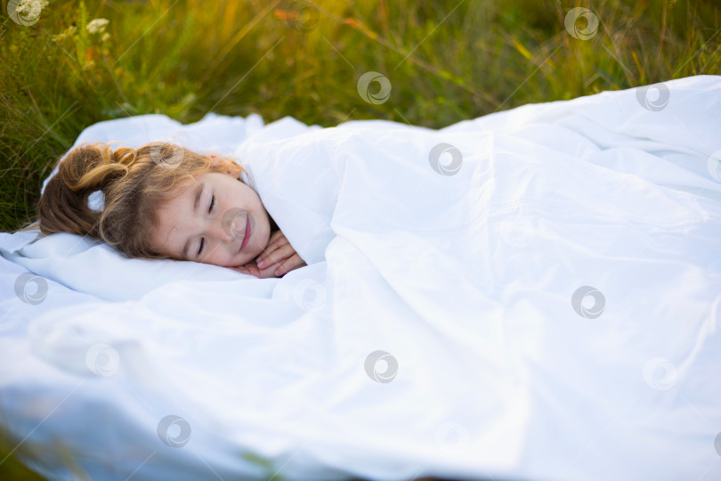 Скачать Девушка спит на белом постельном белье на природе в траве, на свежем воздухе. Защита от комаров, здоровый сон, польза вентиляции, закаливание, чистая природа, экология, здоровье детей фотосток Ozero