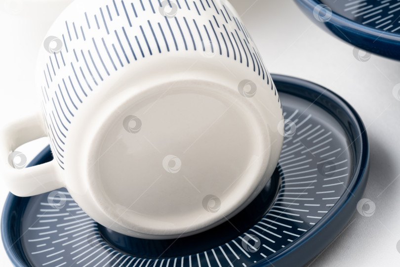 Скачать Снимок крупным планом бело-голубой кружки на блюдце с белым фотосток Ozero