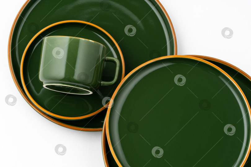 Скачать Набор темно-зеленой керамической посуды с оранжевыми очертаниями на фотосток Ozero