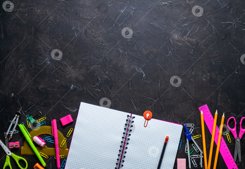 Скачать Школьные принадлежности для школы: блокнот, карандаши, розовая линейка, циркуль, разбросанные по серому столу. Вид сверху. фотосток Ozero