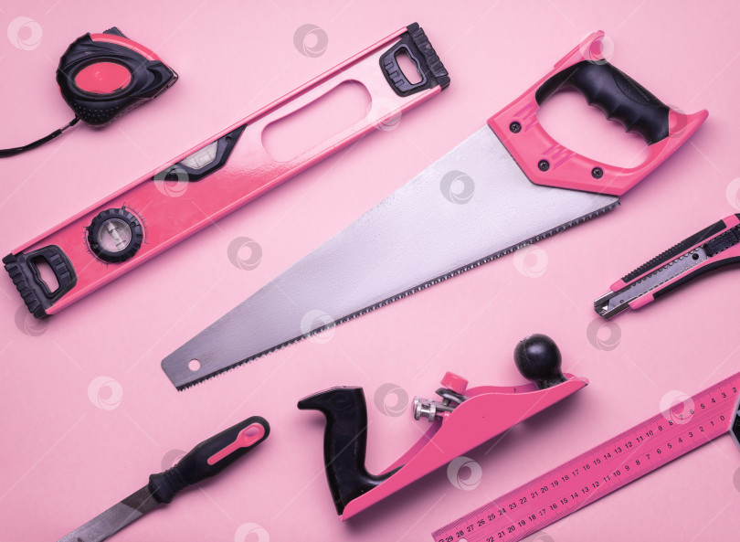 Скачать Творческая провокация: набор ручных инструментов для строительства и ремонта на розовом фоне. фотосток Ozero