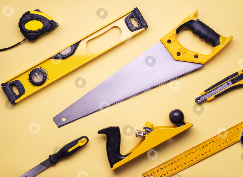 Скачать Макет квартиры: набор ручных инструментов для строительства и ремонта на желтом фоне. фотосток Ozero