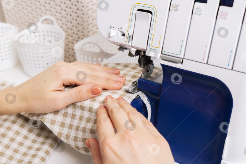 Скачать Женщины за работой: девушка-портниха делает шов на швейной машинке. фотосток Ozero