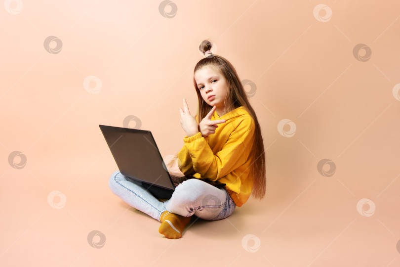Скачать Девушка-школьница с ноутбуком на розовом фоне. фотосток Ozero