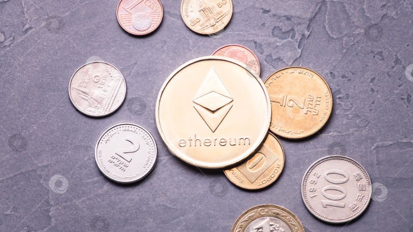 Скачать Превосходство криптовалюты: Большая позолоченная монета ethereum находится среди различных монет мира на сером фоне. фотосток Ozero