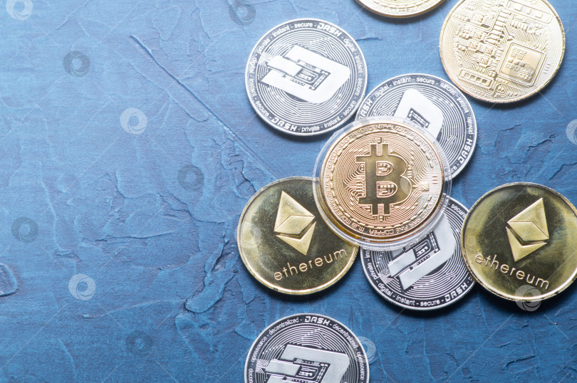 Скачать Превосходство криптовалюты: Монета биткоин находится среди различных монет мира на сером фоне. фотосток Ozero