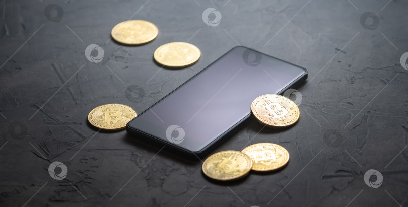 Скачать Заработок на криптовалютах: золотые монеты биткоин и смартфон на сером фоне. Горизонтальная рамка. фотосток Ozero