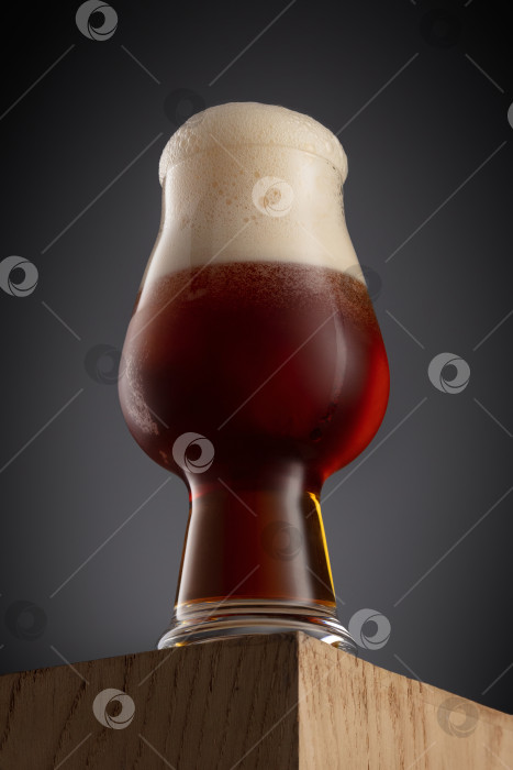 Скачать Бокал свежего и холодного красного или коричневого пива на сером фоне. фотосток Ozero