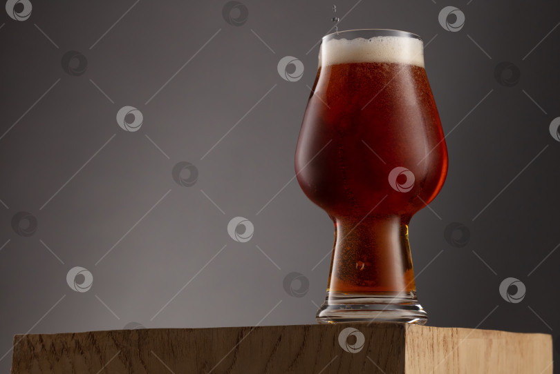 Скачать Бокал свежего и холодного янтарного пива на сером фоне. фотосток Ozero