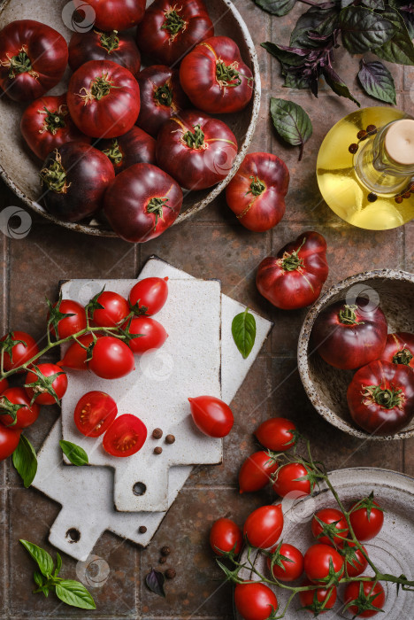 Скачать Урожай помидоров-ассорти, базилика, специй на коричневом кухонном столе. фотосток Ozero