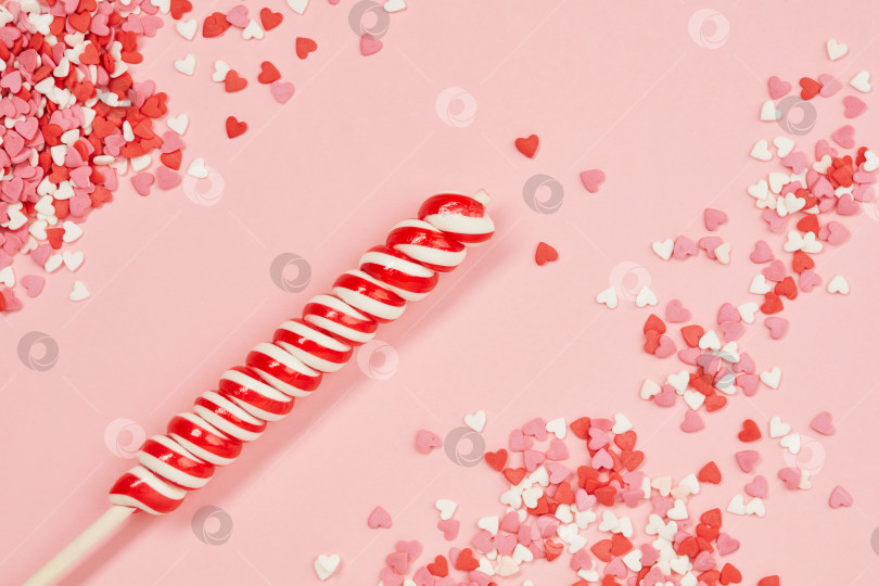 Скачать Фон из ярких конфетных сердечек и леденцового леденца на День Святого Валентина на розовой бумаге. фотосток Ozero