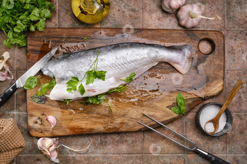 Скачать Вкусная свежая рыба на кухонной доске на темной винтажной подставке фотосток Ozero