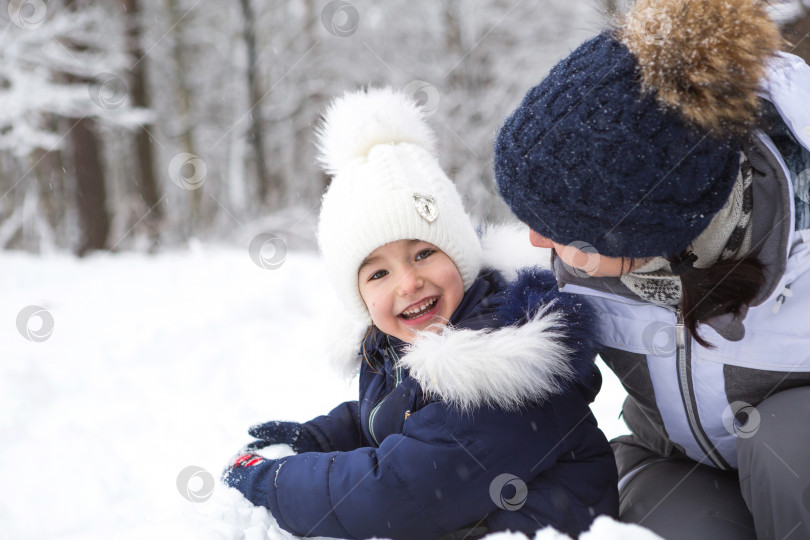 Скачать Мама и дочь играют в снежные игры, строят крепость, лепят снежки. Зимние развлечения на свежем воздухе, активный отдых, забавы в холода в теплой одежде. Отдых на природе, веселое детство, крепкая семья фотосток Ozero