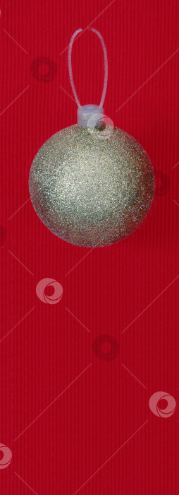 Скачать Золотой рождественский шар, выделенный на красном фоне фотосток Ozero