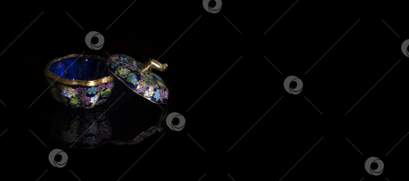 Скачать Традиционная китайская металлическая шкатулка, украшенная разноцветной эмалью, выделяющейся на черном фоне фотосток Ozero