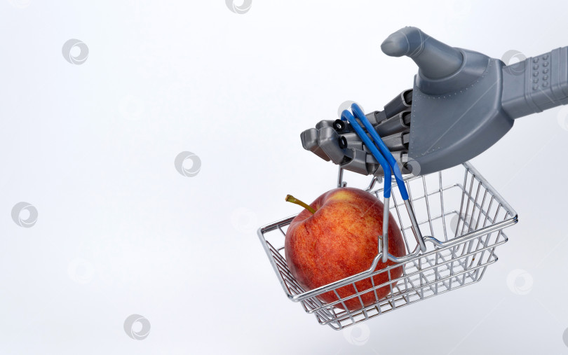 Скачать рука робота держит продуктовую корзину с яблоком. доставка еды с использованием искусственного интеллекта. бесконтактная торговля. фотосток Ozero
