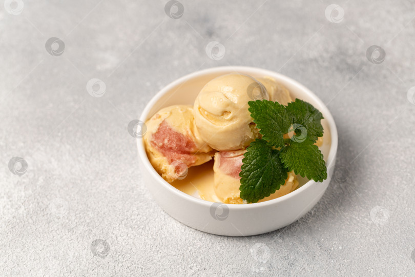 Скачать Персиковое мороженое с клубничным сорбетом, украшенное веточкой апельсина. фотосток Ozero