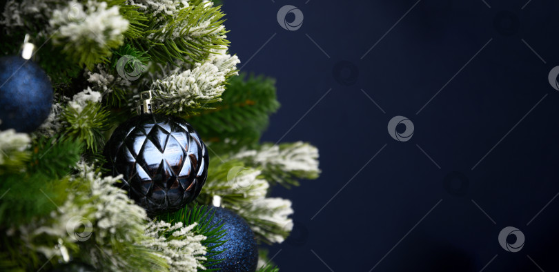 Скачать Рождественский баннер с красными шарами и еловыми ветками на синем фоне. Рождественская поздравительная открытка. фотосток Ozero