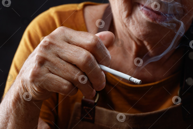 Скачать Крупным планом пожилая женщина курит сигарету. фотосток Ozero
